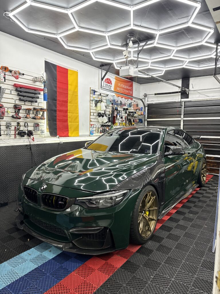 Deep green BMW M4 with bronze wheels and ceramic coating shine