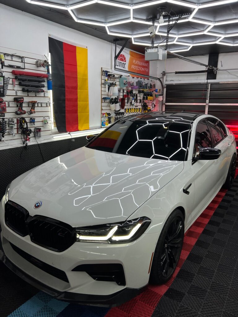 White BMW M5 after ceramic coating with gloss finish under detailing studio lights